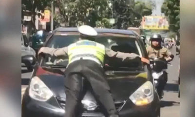 Trafik polisi, kırmızı ışıkta geçen otomobilin kaputuna çıktı